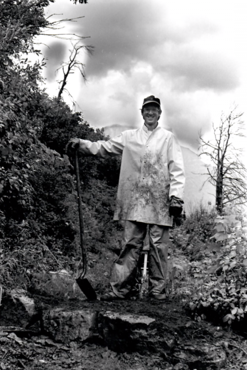 Chuck Cameron smiles with fallen trees the trail crew was clearing from the trails