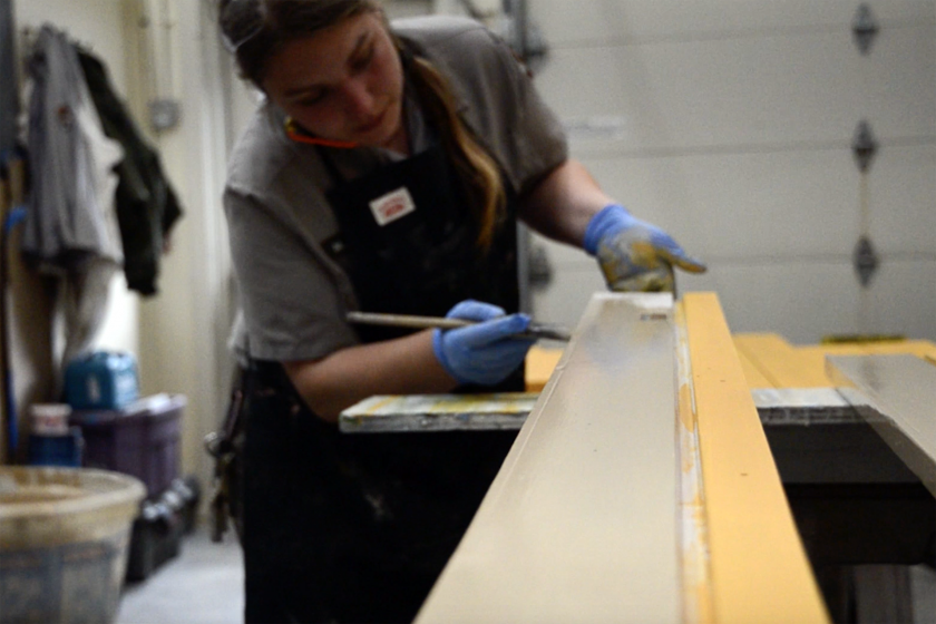 Painting Worker Michelle Harris painting boards at Klondike Goldrush National Historical Park